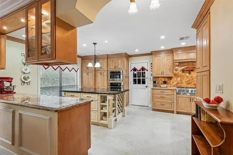 a kitchen with stainless steel appliances kitchen island granite countertop a stove and cabinets