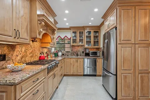 a kitchen with stainless steel appliances granite countertop a refrigerator and a stove