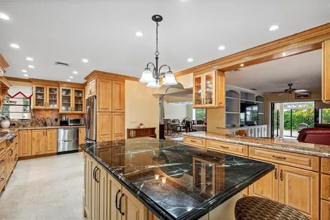 a kitchen with stainless steel appliances granite countertop a kitchen island a stove and a sink