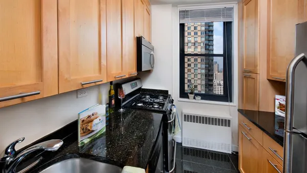a kitchen with a refrigerator a stove and a window