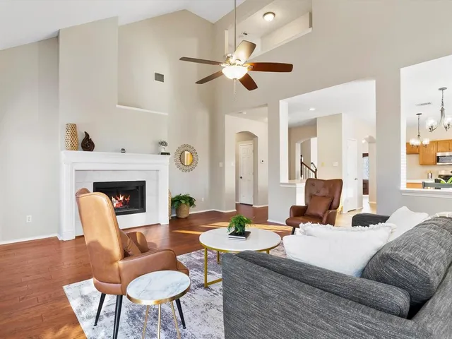 a living room with furniture a fireplace and a chandelier
