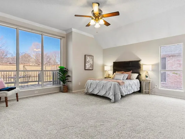 a bedroom with a large bed and a chandelier fan
