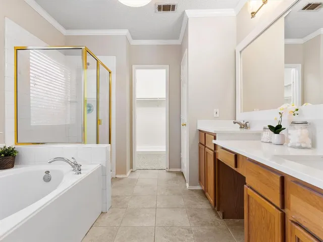 a spacious bathroom with a tub sink and mirror