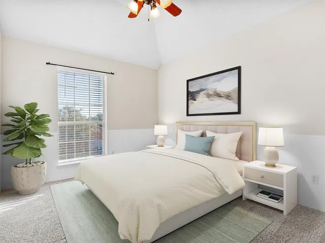a bedroom with a bed and a potted plant