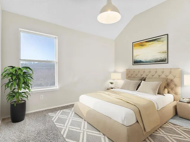 a bedroom with a bed and a potted plant