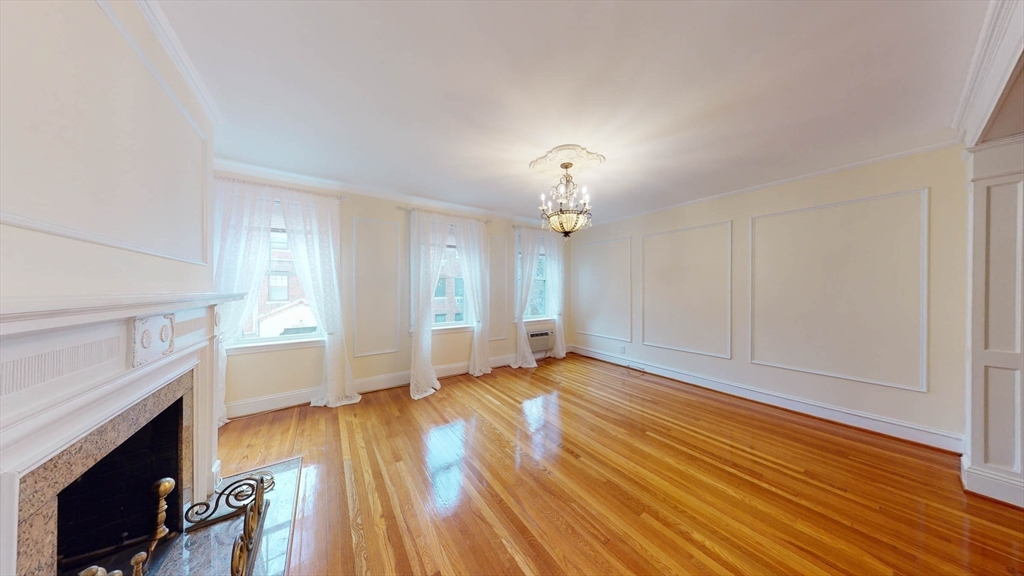 311 Tappan Street, Unit 3 Brookline, MA 02445 - Photo 6 of 35 an empty room with wooden floor fireplace and windows