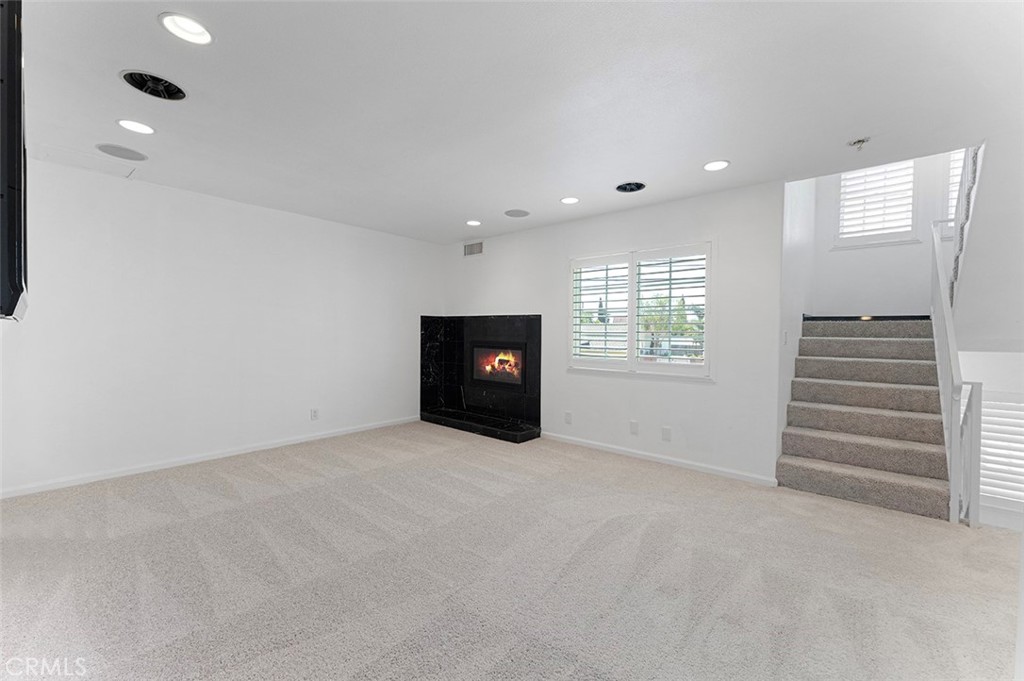 13036 Springarden Lane Westminster, CA 92683 - Photo 12 of 41 an empty room with a fireplace and windows
