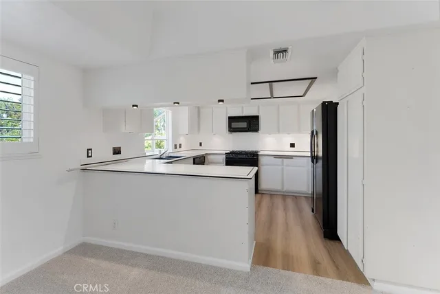 a kitchen with stainless steel appliances white cabinets a sink and a stove