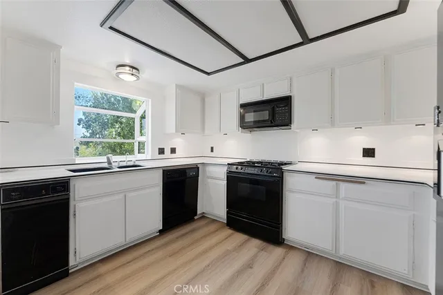 a kitchen with white cabinets and refrigerator