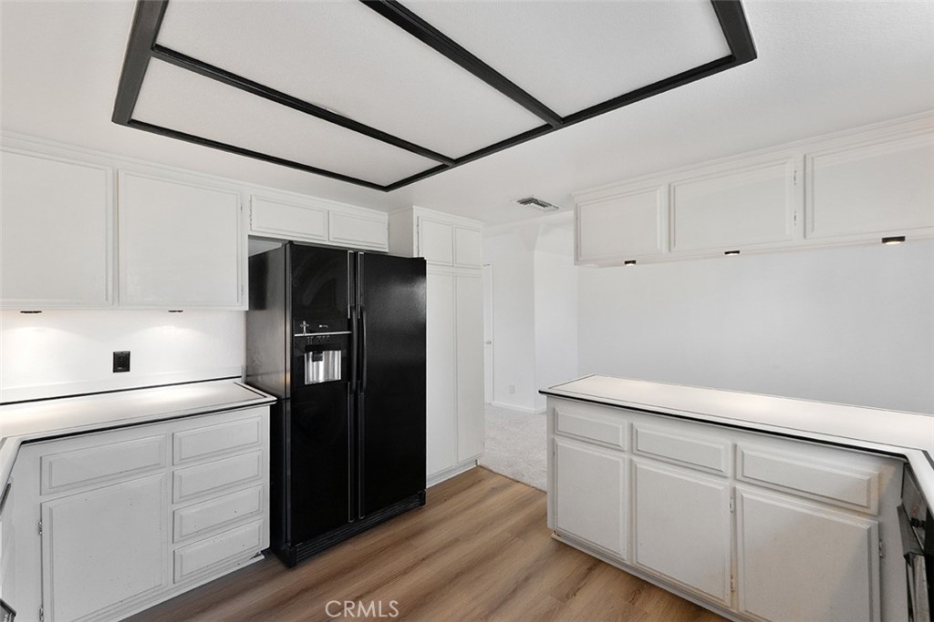 13036 Springarden Lane Westminster, CA 92683 - Photo 19 of 41 a kitchen with white cabinets and refrigerator