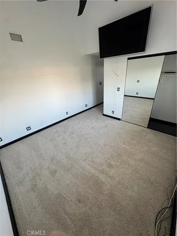 an empty room with a ceiling fan and a window