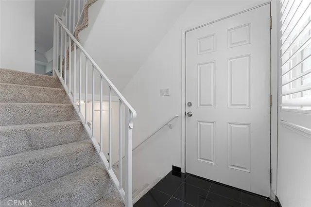 a view of staircase with lots of frames on wall and stairs