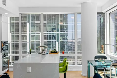 a kitchen with a dining table chairs and white appliances