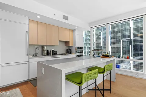 a kitchen with stainless steel appliances a stove and white cabinets