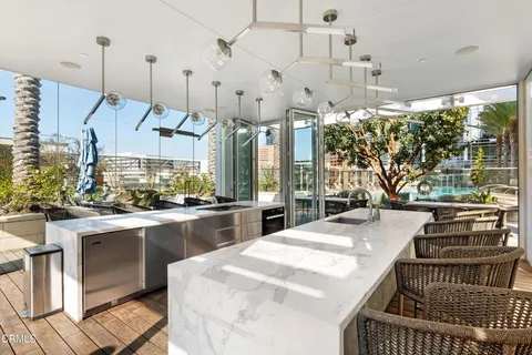 a room with stainless steel appliances kitchen island granite countertop furniture and a chandelier