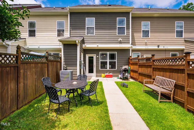 a view of a chair and table in backyard of the house