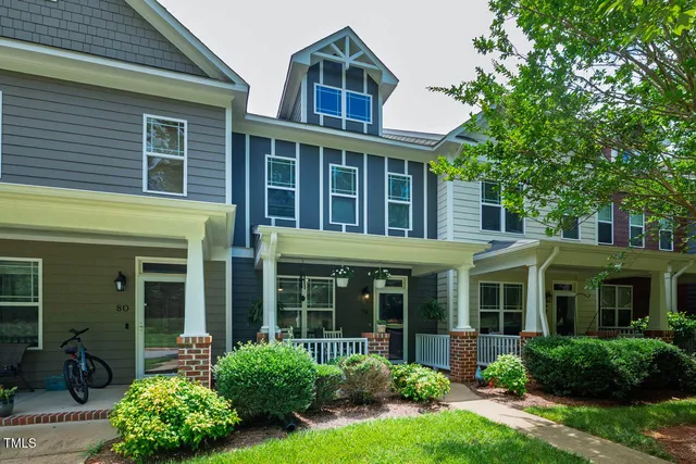 a front view of a house with a garden and plants