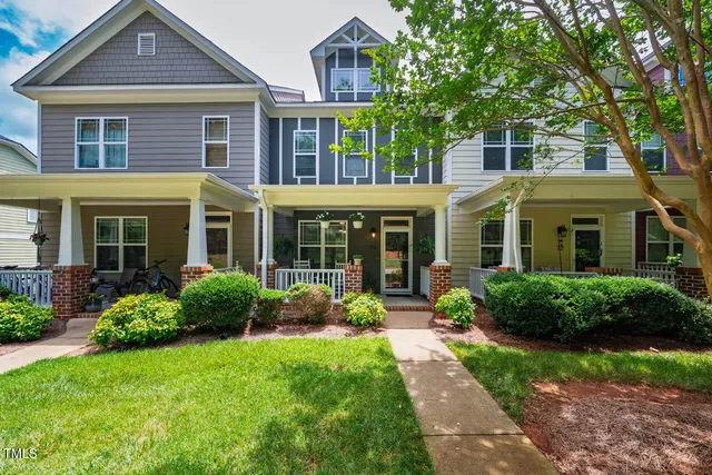 a living room with furniture a flat screen tv and kitchen view