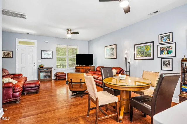 a kitchen with stainless steel appliances granite countertop a table chairs sink and cabinets