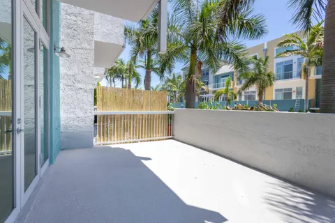 a view of a house with a large window and palm trees