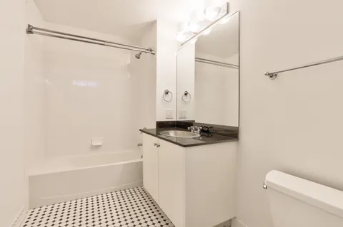 a bathroom with a sink a toilet a shower and a mirror