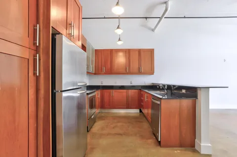 a kitchen with stainless steel appliances granite countertop a refrigerator and a stove