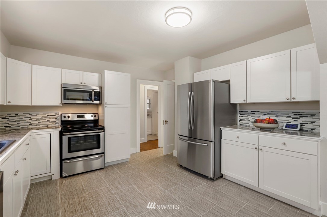 5431 Broadway Everett, WA 98203 - Photo 10 of 22 a kitchen with granite countertop a refrigerator stove and microwave