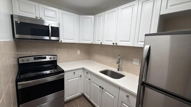 a kitchen with stainless steel appliances granite countertop a refrigerator stove and microwave