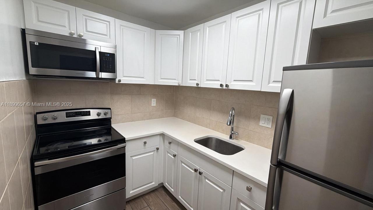 a kitchen with stainless steel appliances granite countertop a refrigerator stove and microwave
