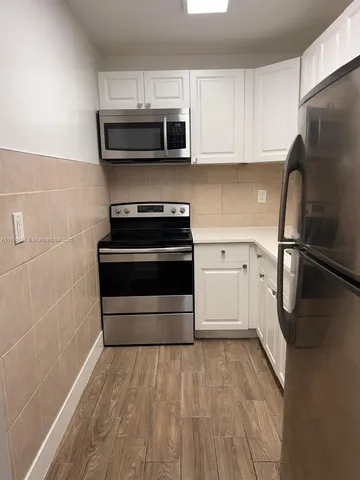 a kitchen with a refrigerator stove and microwave
