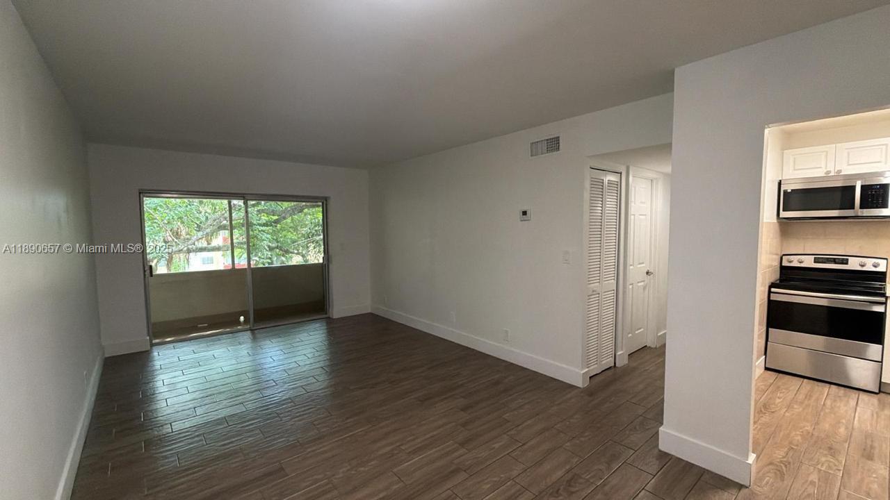 271 Bonnie Boulevard, Unit 205 Palm Springs, FL 33461 - Photo 7 of 12 wooden floor in an empty room with a window