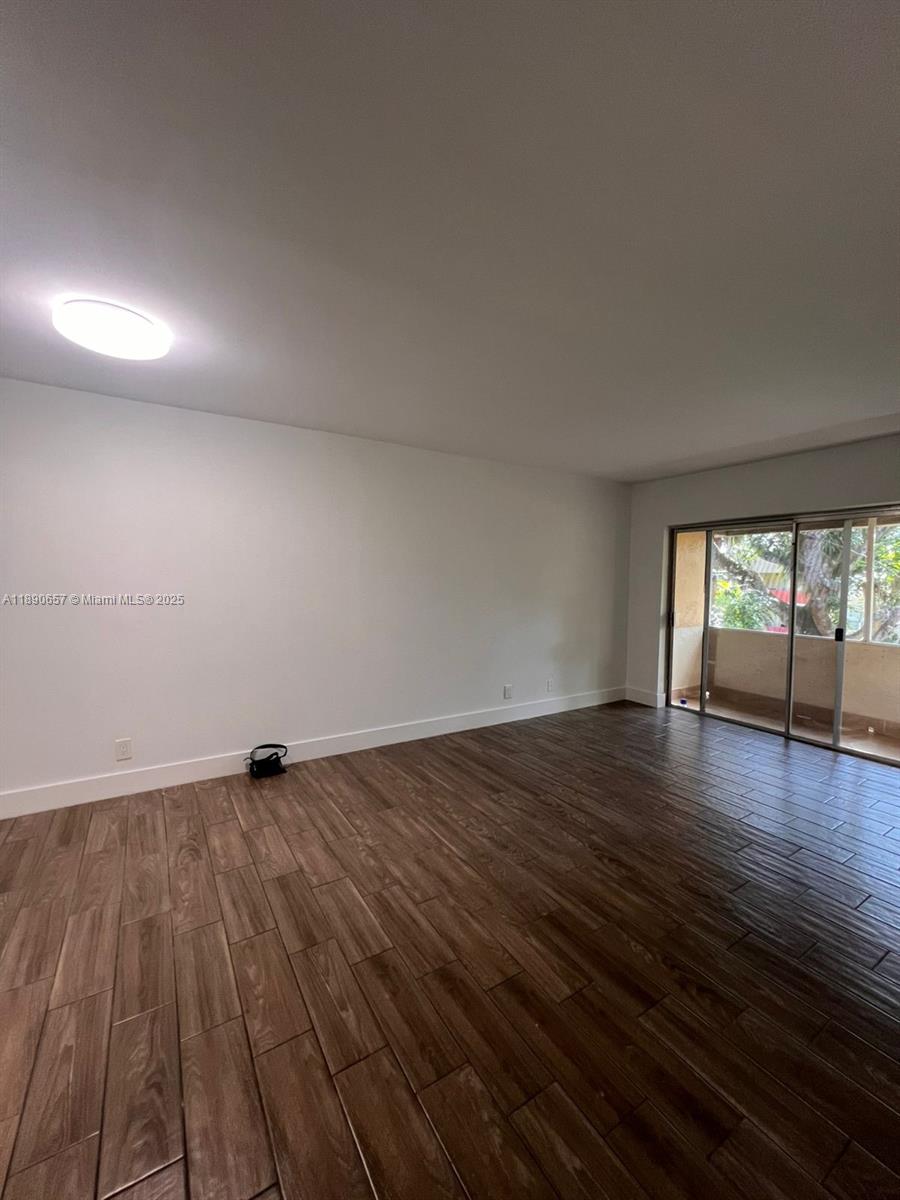 271 Bonnie Boulevard, Unit 205 Palm Springs, FL 33461 - Photo 9 of 12 an empty room with wooden floor and windows