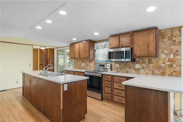 a kitchen with stainless steel appliances granite countertop a sink stove and microwave