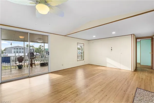 an empty room with wooden floor and glass door