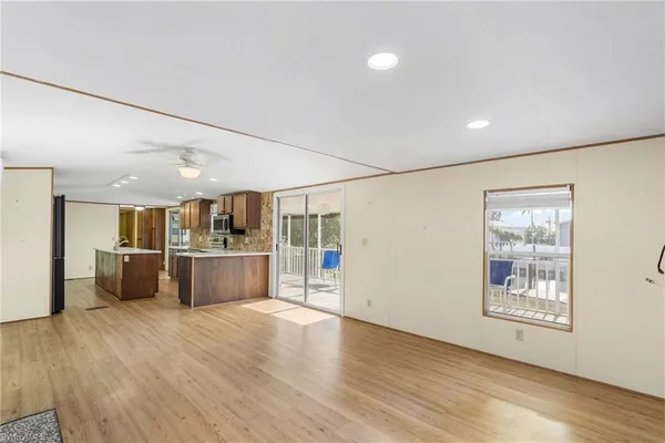 a view of a big room with wooden floor and windows