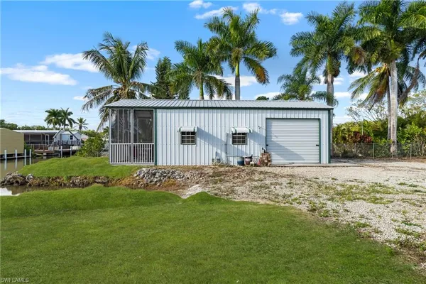 a view of a house with a yard and palm trees