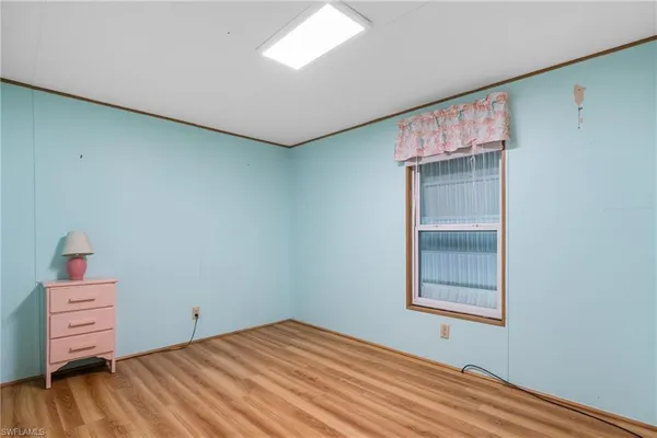 a view of empty room with a window and wooden floor