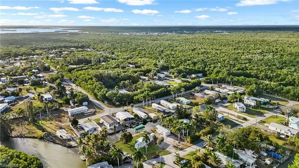an aerial view of residential houses with outdoor space and trees