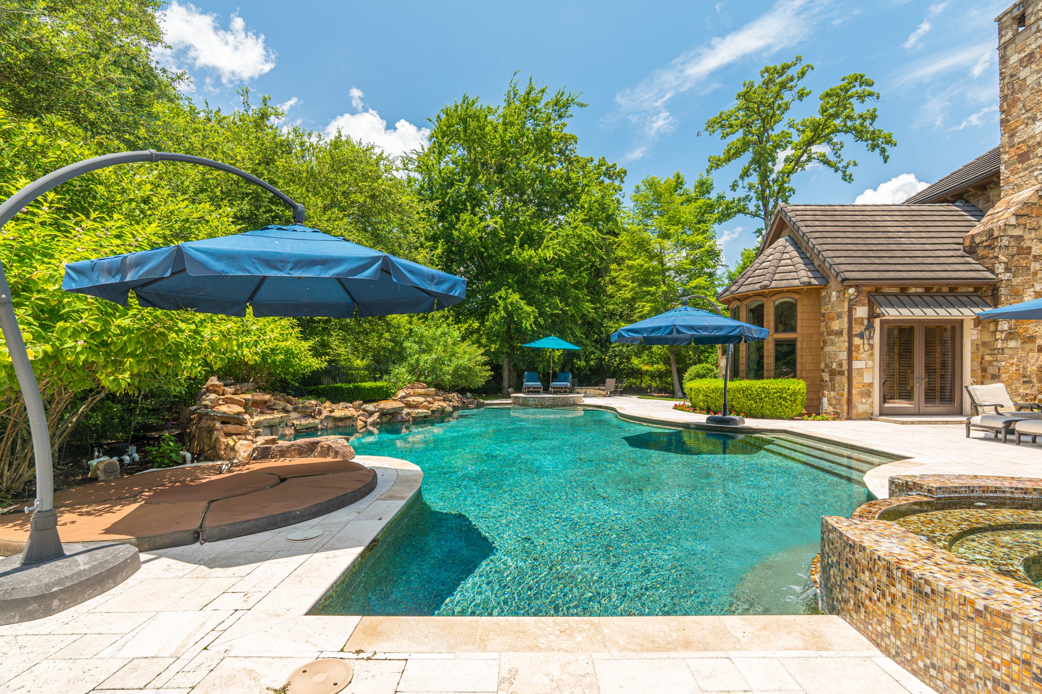 247 South Fazio Way Spring, TX 77389 - Photo 10 of 17 Resort-style living comes to life with a stunning pool and spa, sun shelf seating, water features, and multiple lounging areas surrounded by lush mature landscaping providing secluded atmosphere.