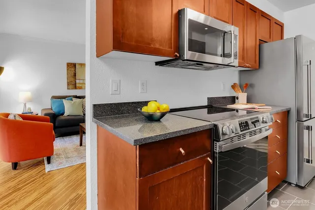 a kitchen with stainless steel appliances granite countertop a stove a sink and a microwave