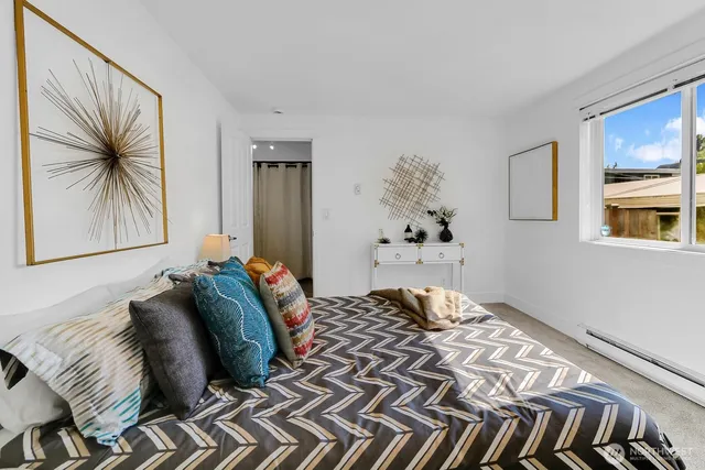 a bedroom with a bed and a painting on the wall