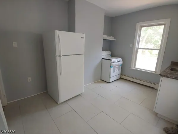 a kitchen with a refrigerator and a stove top oven
