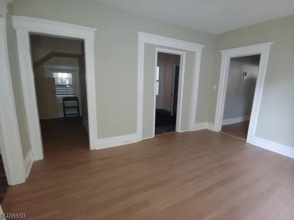 a view of a hallway with wooden floor and closet