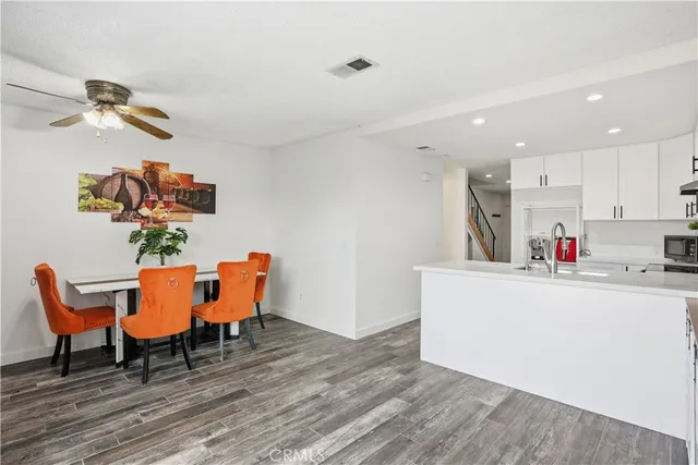 a living room with furniture and a dining table with wooden floor