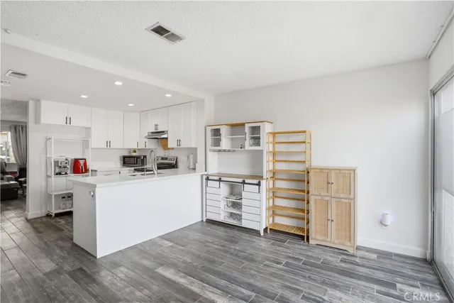 a kitchen with a refrigerator and white cabinets