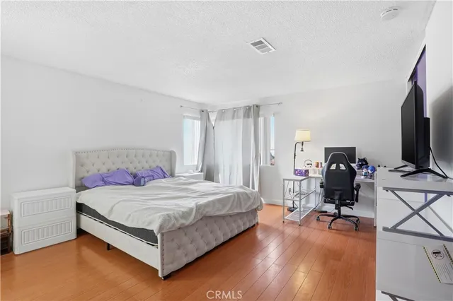 a bedroom with a bed flat screen tv and dresser