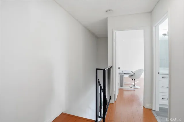 a view of a hallway with closet and wooden floor