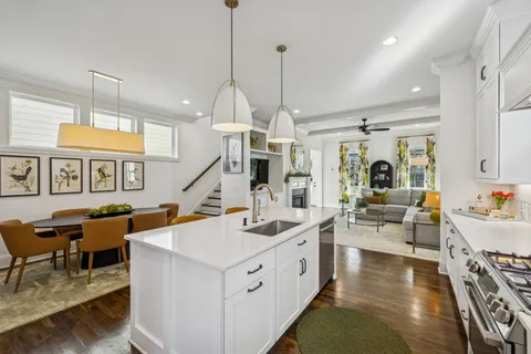 a very nice looking living room with a dining table a rug a chandelier and a view of living room