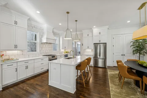 a large kitchen with cabinets table and chairs