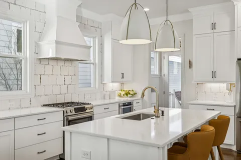 a kitchen with a sink stove and white cabinets